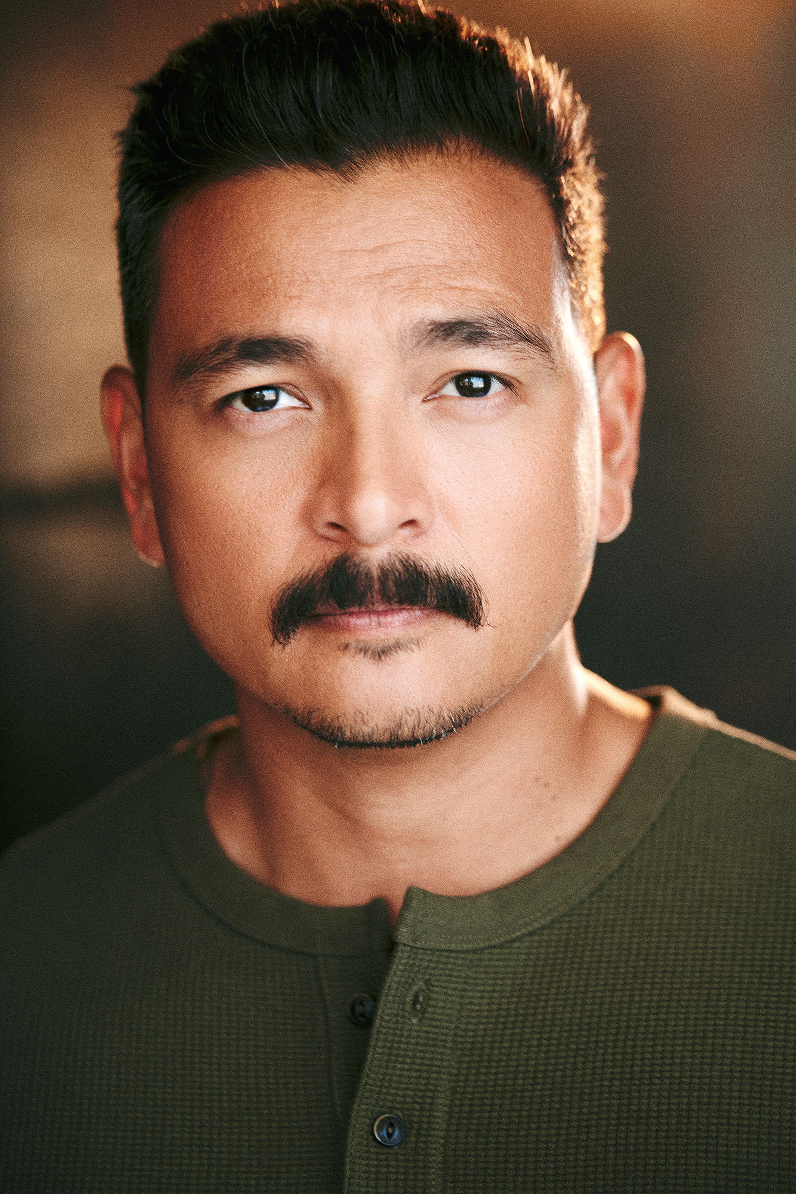 headshot with serious stare and mustache